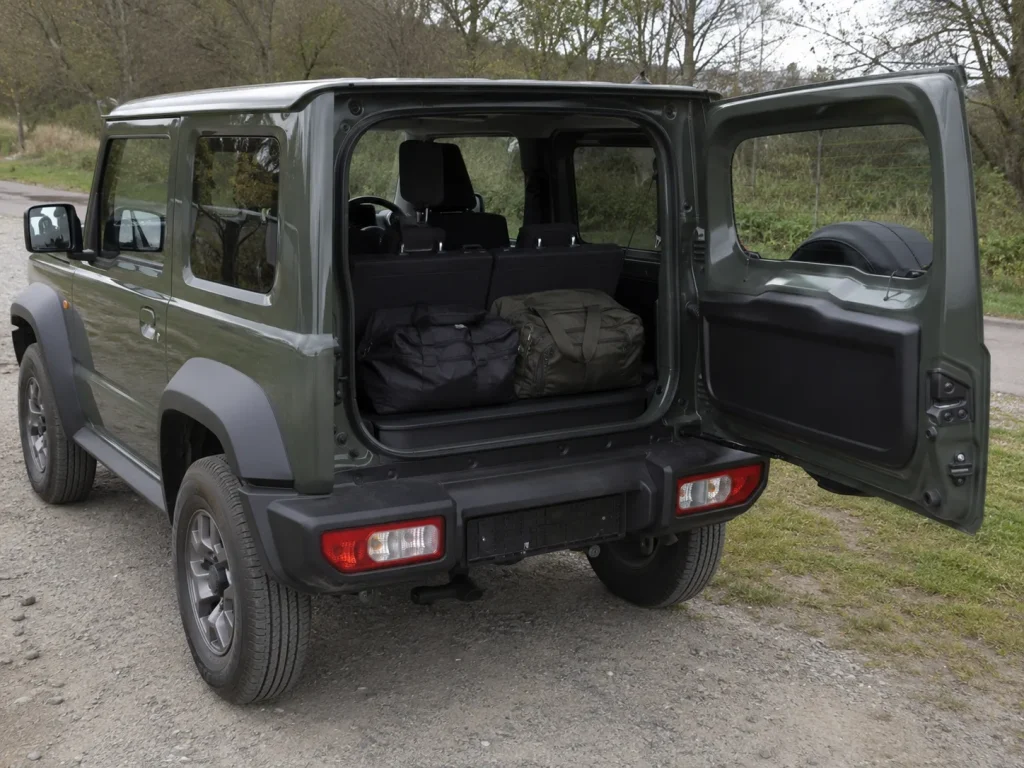 Open tailgate of a three-door Suzuki Jimny showing its small boot