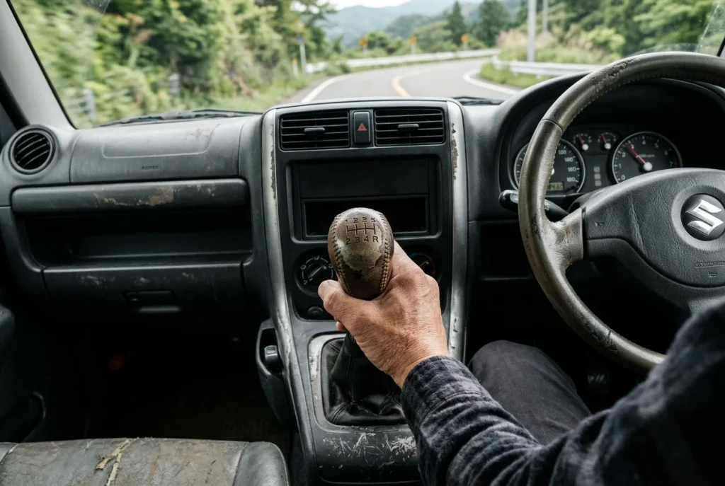 Hand on a JB23 gear lever in fifth