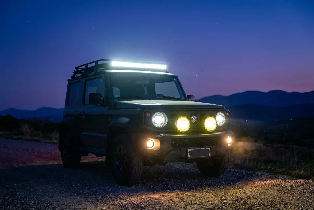 Jimny with light bar, spotlights and fog lights glowing at dusk
