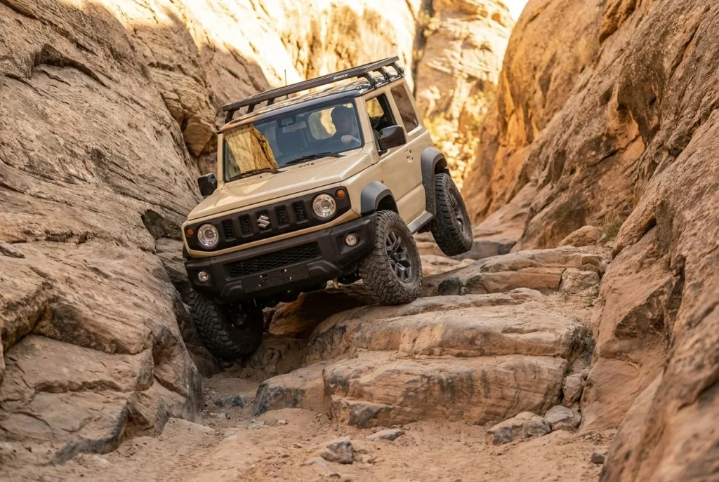 Suzuki Jimny flexing up a stepped rocky ledge